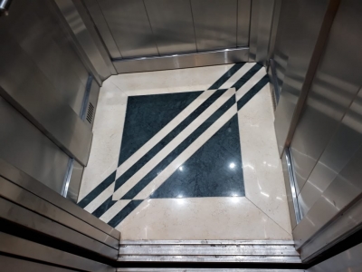 Piso de ascensor en marmol sahara combinado con verde guatemala